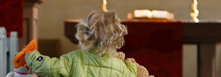 Kind auf dem Weg zum Altar einer Kirche.